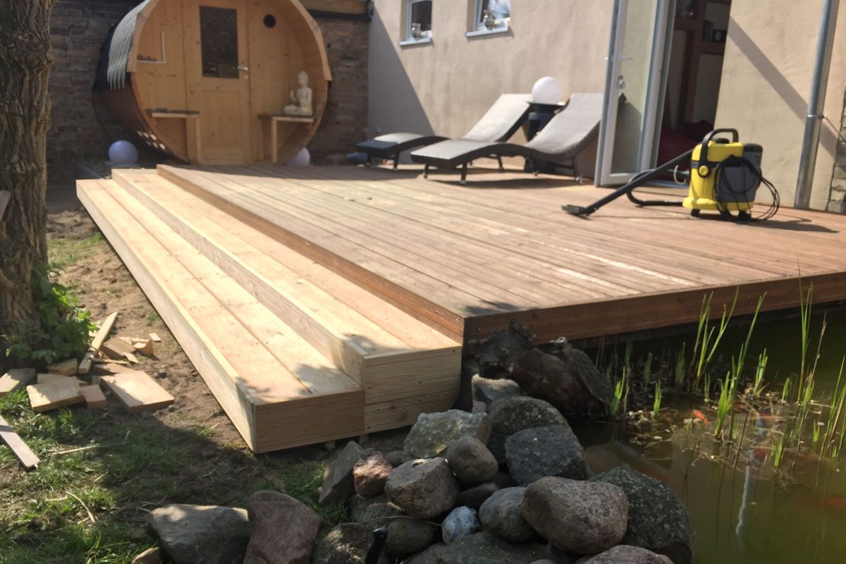 Terrasse am Teich mit Fass-Sauna